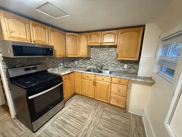a kitchen with stainless steel appliances granite countertop a stove a sink and a microwave