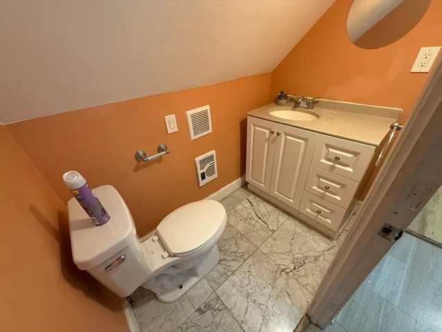 a bathroom with a toilet mirror and vanity
