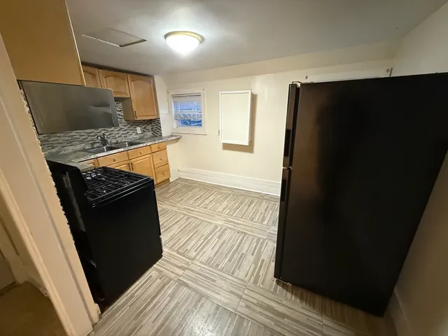 a kitchen with granite countertop a refrigerator and a stove