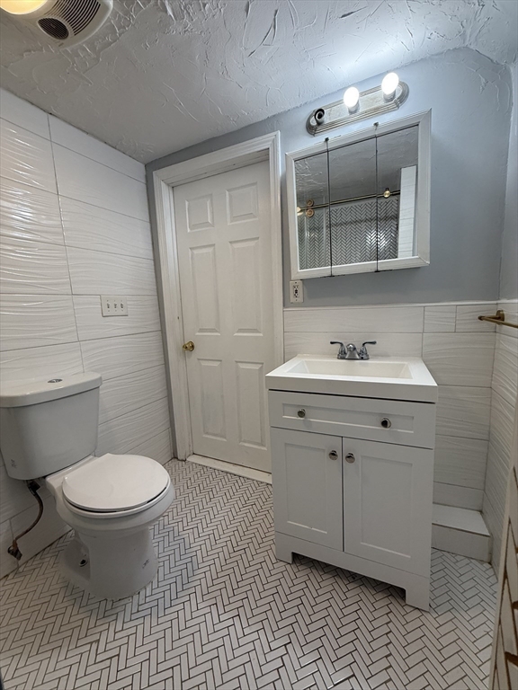 1208 Morton Street, Unit 3 Boston, MA 02126 - Photo 5 of 17 a bathroom with a sink toilet and mirror