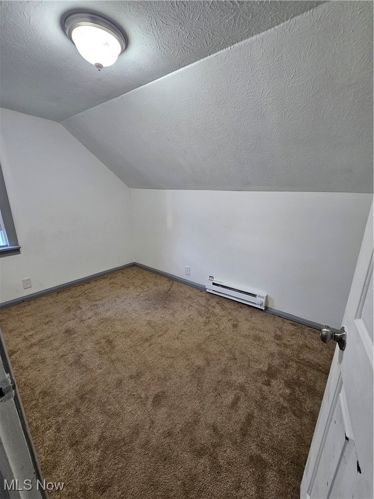 2708 Highway 6 Rome, OH 44085 - Photo 9 of 27 Bonus room featuring a textured ceiling, lofted ceiling, a baseboard radiator, and carpet