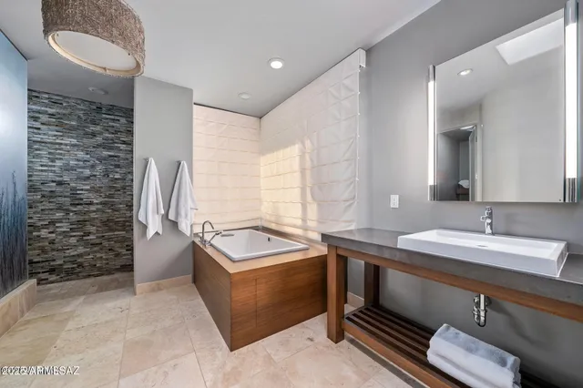 a spacious bathroom with a double vanity sink a mirror and a bathtub