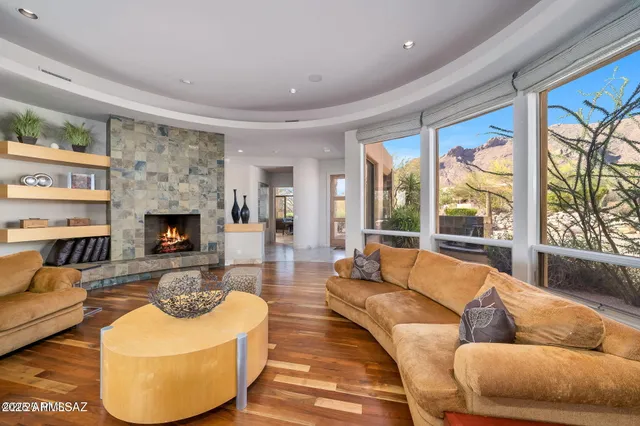 a living room with fireplace furniture and a large window