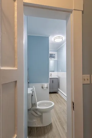 a white toilet sitting next to a bathroom sink and a mirror