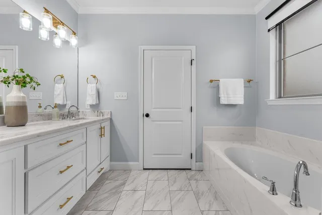 a bathroom with a tub sink and mirror