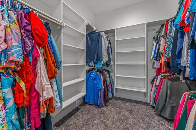 a view of walk in closet with clothes and shoes
