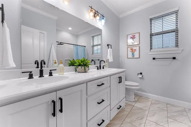 a bathroom with a granite countertop sink mirror and toilet