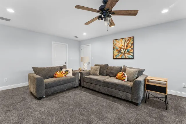 a living room with furniture and a ceiling fan