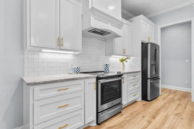 a kitchen with stainless steel appliances granite countertop a refrigerator and a stove