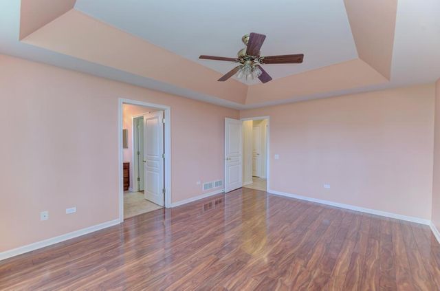 a bathroom with a granite countertop sink a toilet a mirror and window