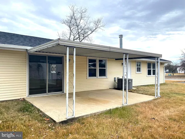 a view of a house with a big yard and large tree