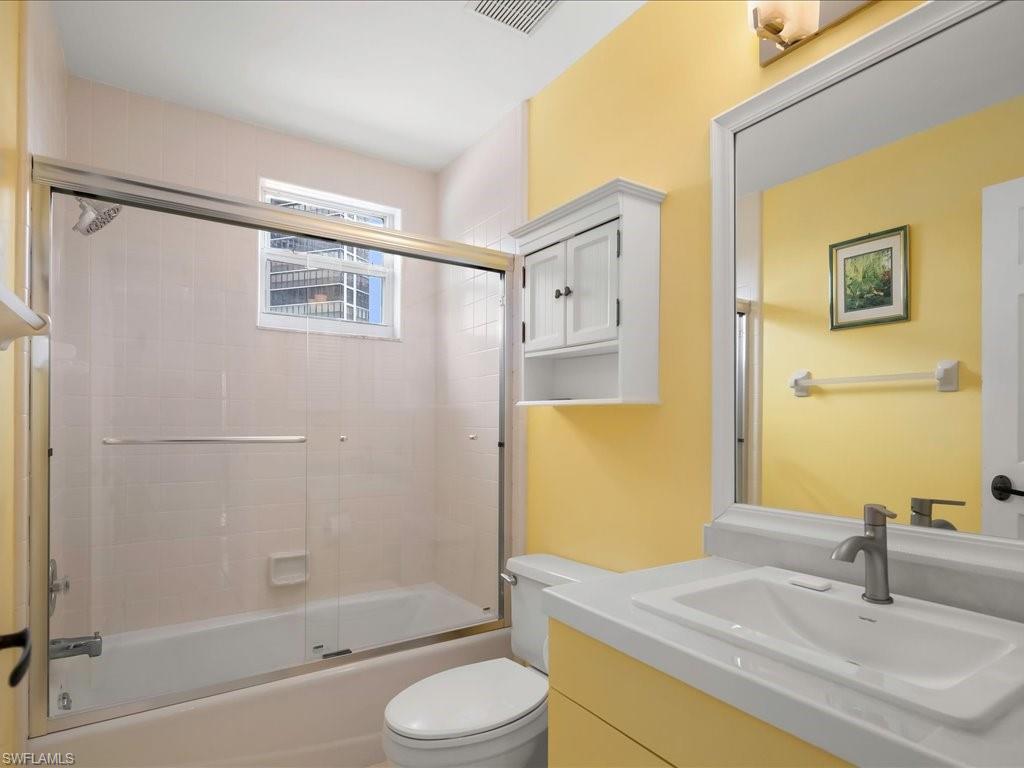 5550 Heron Point Drive, Unit 105 Naples, FL 34108 - Photo 13 of 20 a bathroom with a granite countertop sink toilet and shower