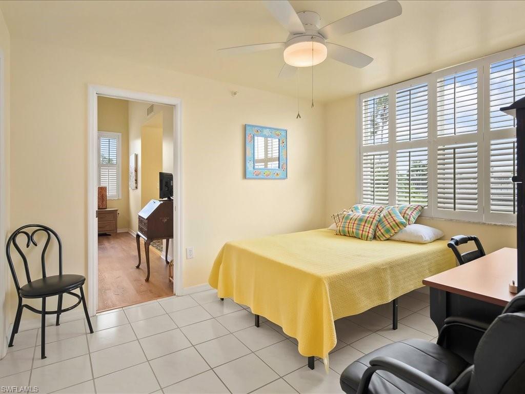 5550 Heron Point Drive, Unit 105 Naples, FL 34108 - Photo 14 of 20 a bedroom with a bed and a table in it