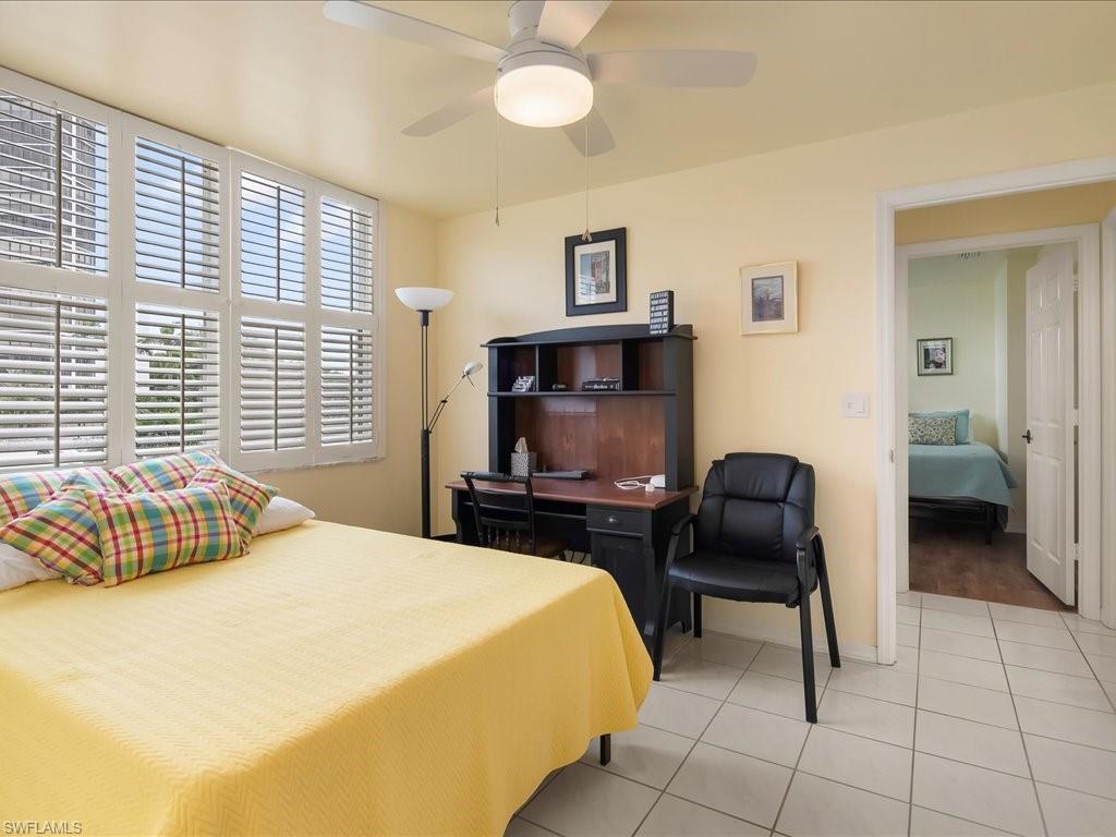 5550 Heron Point Drive, Unit 105 Naples, FL 34108 - Photo 15 of 20 a bedroom with a bed and a chair