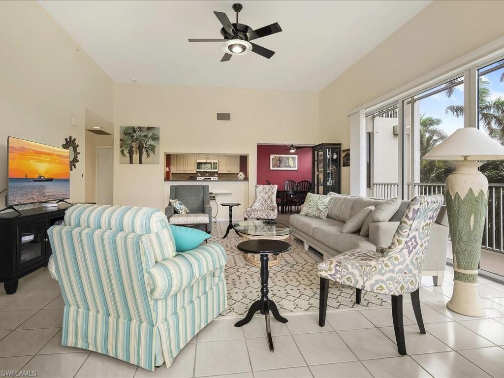 5550 Heron Point Drive, Unit 105 Naples, FL 34108 - Photo 3 of 20 a living room with furniture and a flat screen tv