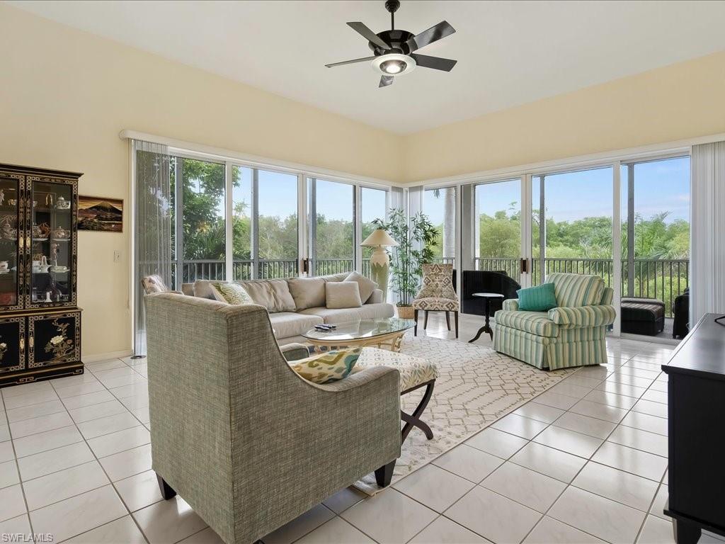 5550 Heron Point Drive, Unit 105 Naples, FL 34108 - Photo 4 of 20 a living room with furniture and a floor to ceiling window
