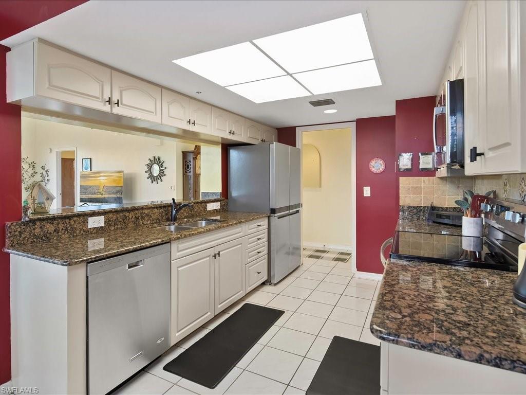 5550 Heron Point Drive, Unit 105 Naples, FL 34108 - Photo 7 of 20 a large kitchen with granite countertop a sink and cabinets