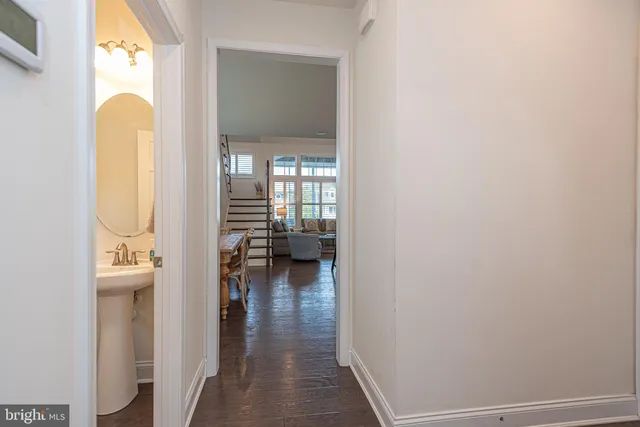 a kitchen with stainless steel appliances granite countertop a sink dishwasher a refrigerator and white cabinets with wooden floor