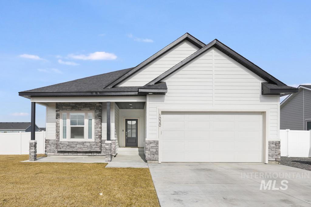 Craftsman inspired home featuring stone siding, driveway, an attached garage, a porch, and a shingled roof