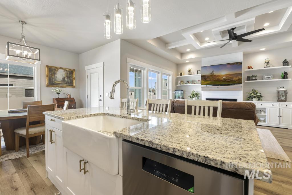1020 13th Street Rupert, ID 83350 - Photo 12 of 30 Kitchen featuring stainless steel dishwasher, light stone countertops, light wood finished floors, and white cabinets