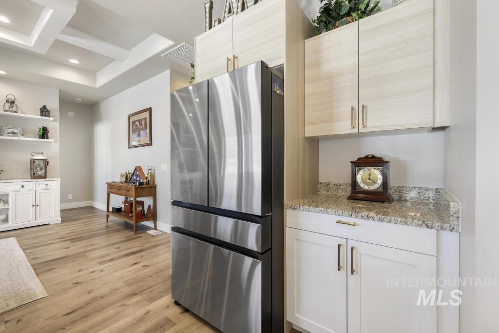 1020 13th Street Rupert, ID 83350 - Photo 13 of 30 Kitchen featuring freestanding refrigerator, open shelves, coffered ceiling, light wood-style floors, and light stone countertops