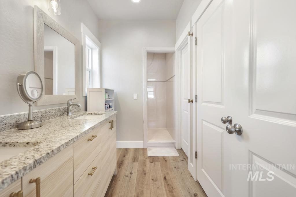1020 13th Street Rupert, ID 83350 - Photo 20 of 30 Bathroom featuring double vanity, tiled shower, and light wood-style floors