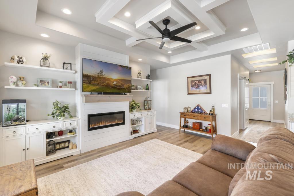 1020 13th Street Rupert, ID 83350 - Photo 7 of 30 Living area with coffered ceiling, ceiling fan, recessed lighting, light wood finished floors, and a glass covered fireplace