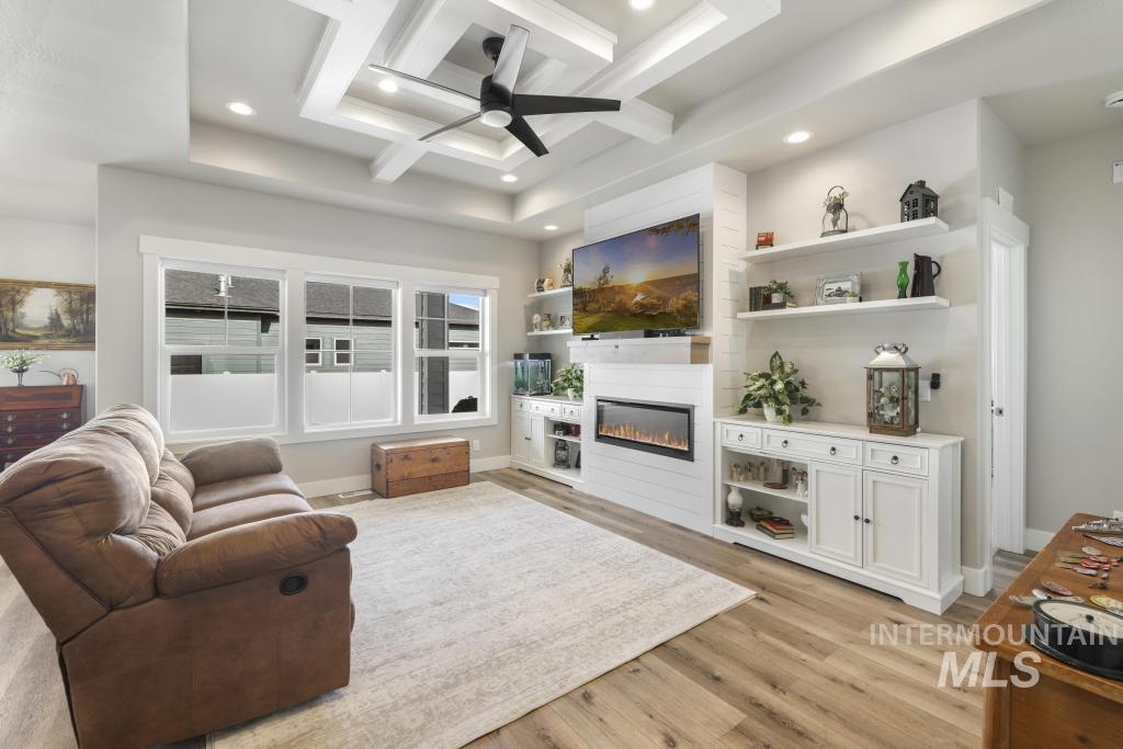 1020 13th Street Rupert, ID 83350 - Photo 8 of 30 Living area with coffered ceiling, a ceiling fan, a glass covered fireplace, recessed lighting, and light wood-type flooring