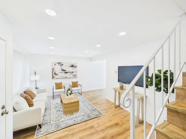 a bed sitting in a spacious bedroom next to a window