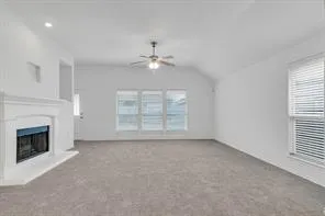 an empty room with windows and fireplace