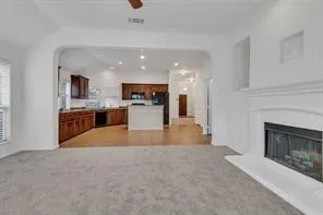 an empty room with windows and fireplace