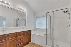 an empty room with chandelier fan and kitchen view