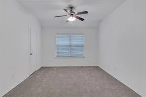 an empty room with fan and windows