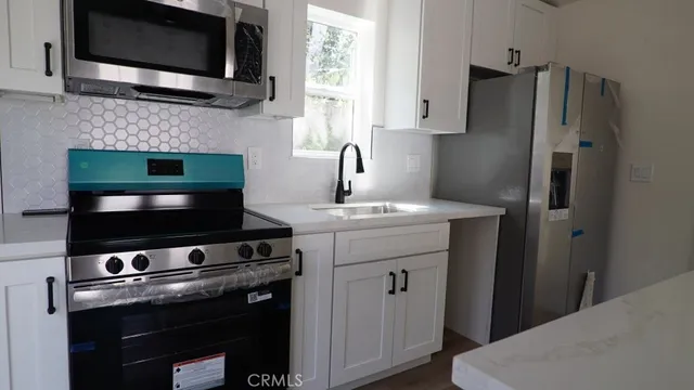 a kitchen with stainless steel appliances a stove microwave and sink