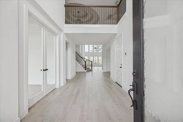 a view of a hallway with wooden floor and staircase