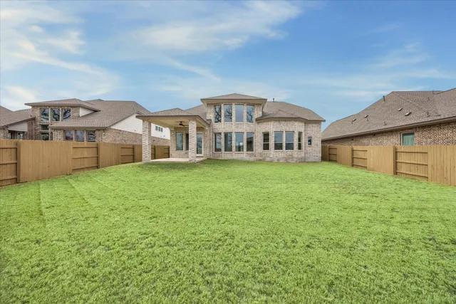 a front view of a house with a garden and lake view