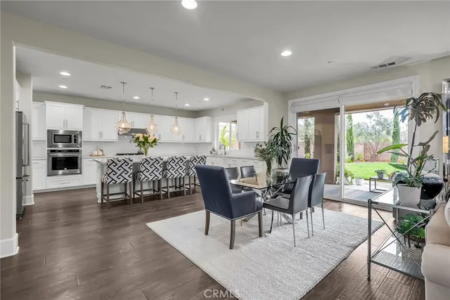 a living room with furniture a flat screen tv and kitchen view