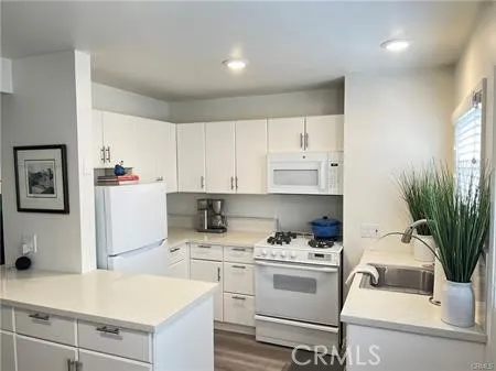 a kitchen with a white stove top oven and white cabinets