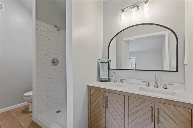 a bathroom with a sink a toilet and shower