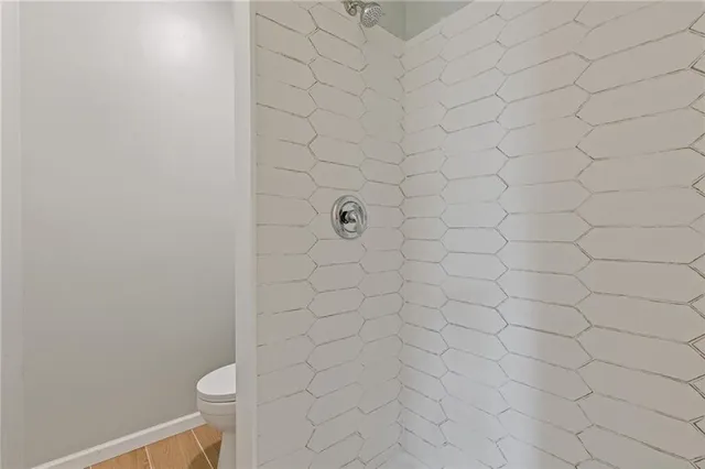 a bathroom with a white toilet and a shower