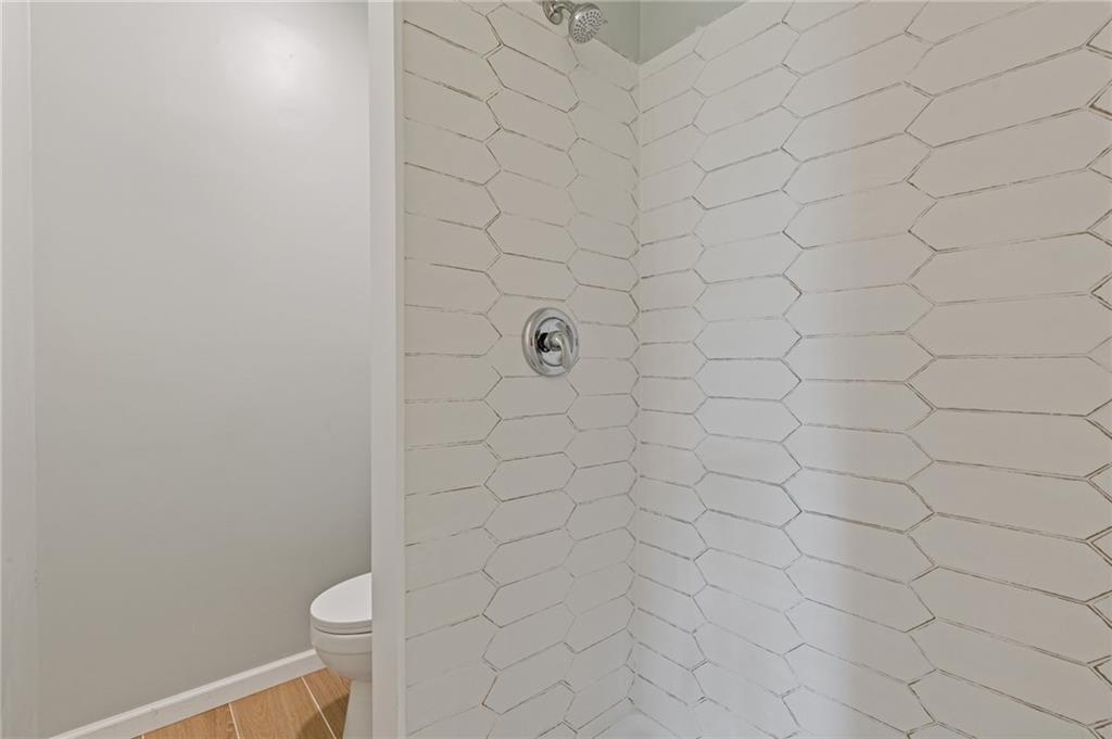 1312 Milstead Avenue Conyers, GA 30012 - Photo 17 of 34 a bathroom with a white toilet and a shower