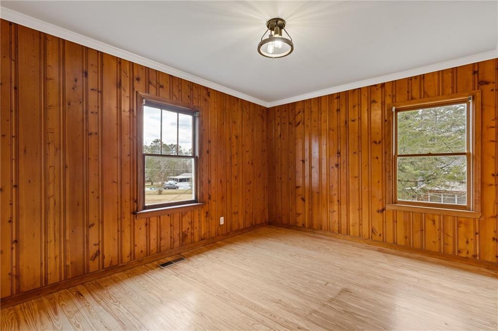 1312 Milstead Avenue Conyers, GA 30012 - Photo 18 of 34 an empty room with wooden floor and windows