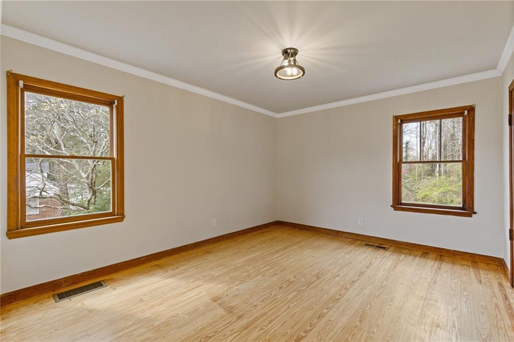 1312 Milstead Avenue Conyers, GA 30012 - Photo 20 of 34 a view of an empty room with a window and wooden floor
