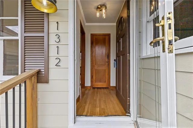 a view of a hallway with wooden floor and staircase