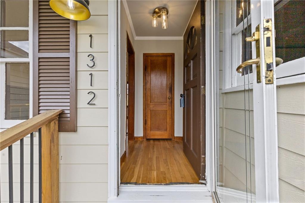 1312 Milstead Avenue Conyers, GA 30012 - Photo 2 of 34 a view of a hallway with wooden floor and staircase