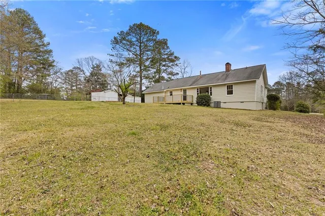 a view of a big yard next to a house with large trees