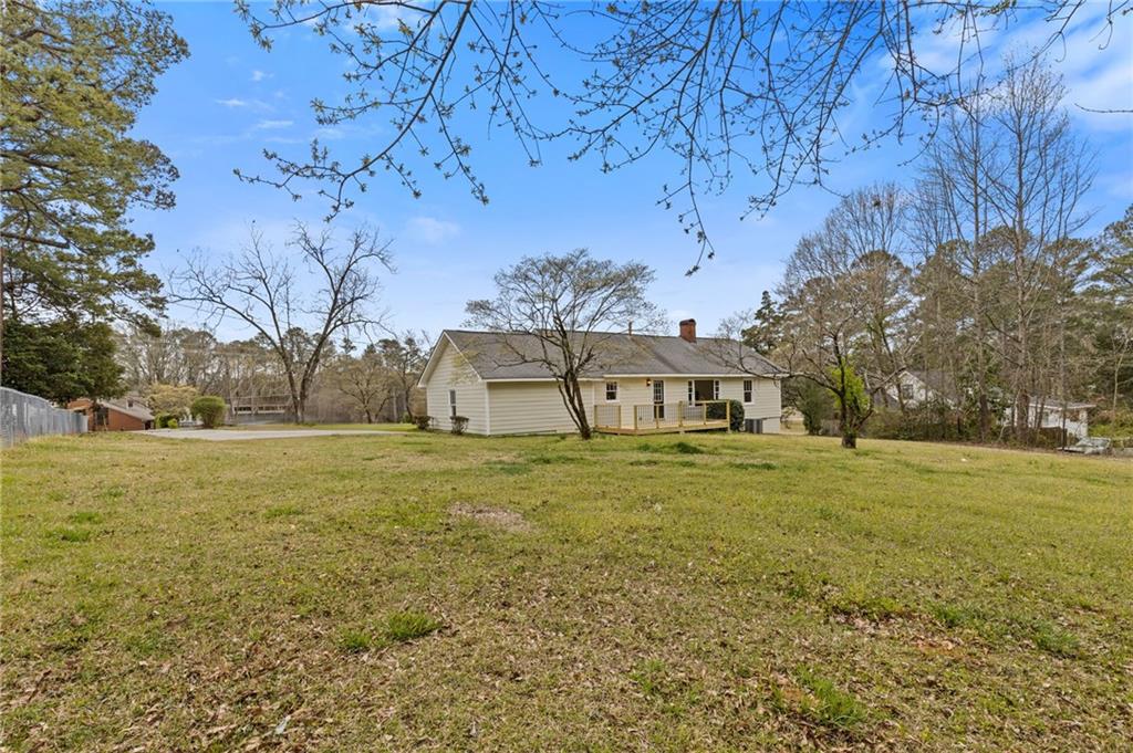 1312 Milstead Avenue Conyers, GA 30012 - Photo 27 of 34 a view of a big yard next to a house with large trees