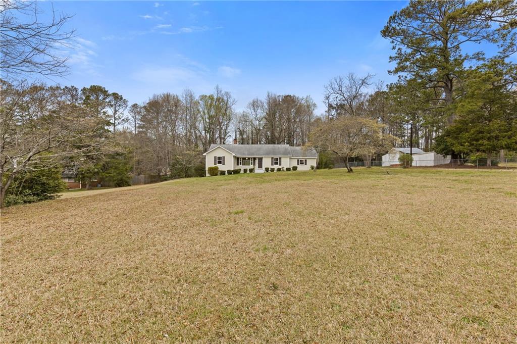 1312 Milstead Avenue Conyers, GA 30012 - Photo 4 of 34 a view of a field with trees in the background