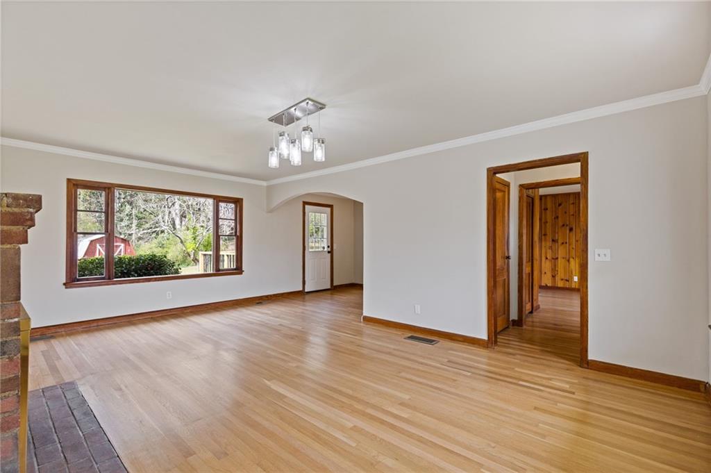1312 Milstead Avenue Conyers, GA 30012 - Photo 8 of 34 a view of an empty room with window and wooden floor