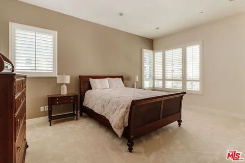 a bed sitting in a bedroom next to a window